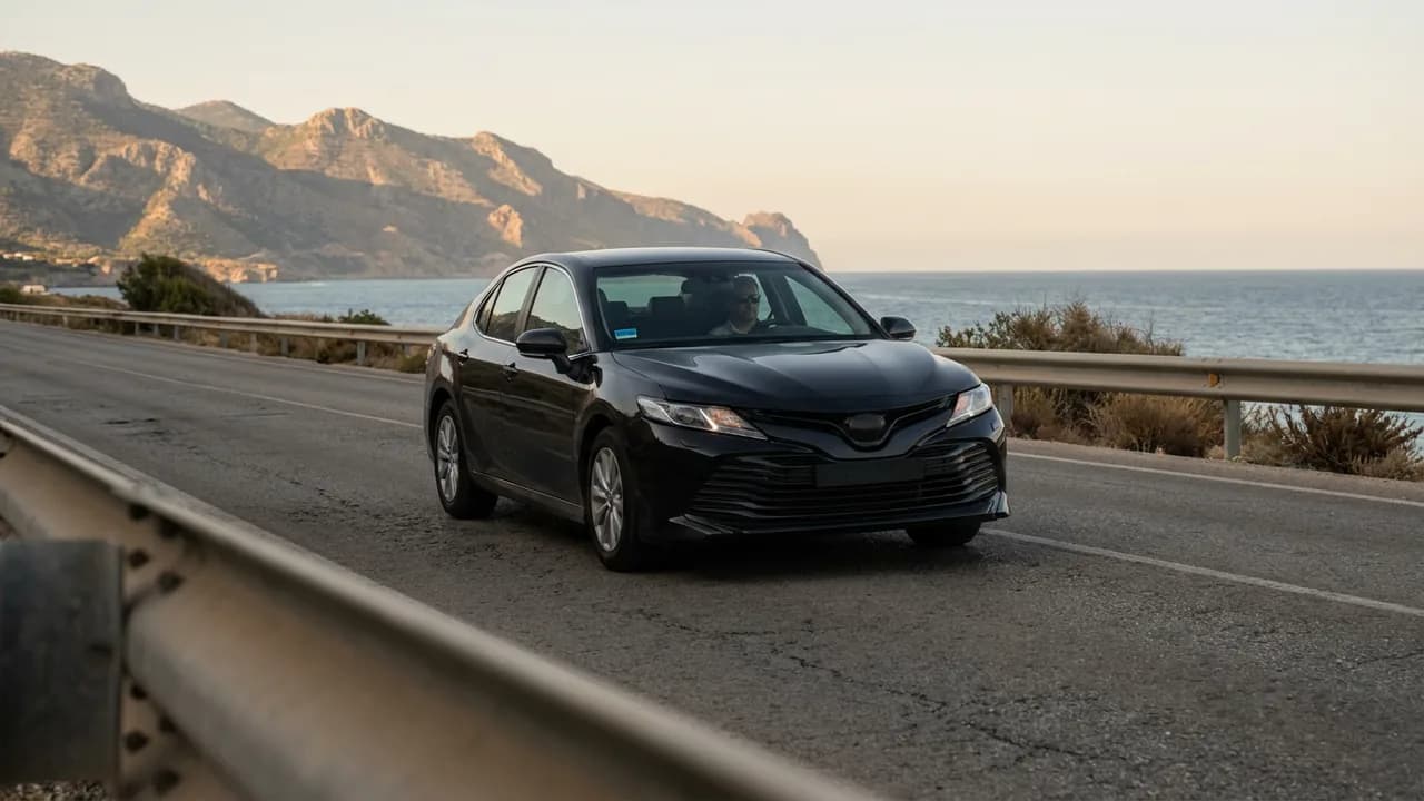 A black sedan with only the driver aboard heads back empty along the coast road between Marbella and Malaga after dropping off a passenger